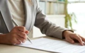cropped-mid-section-unrecognizable-woman-signing-document-1